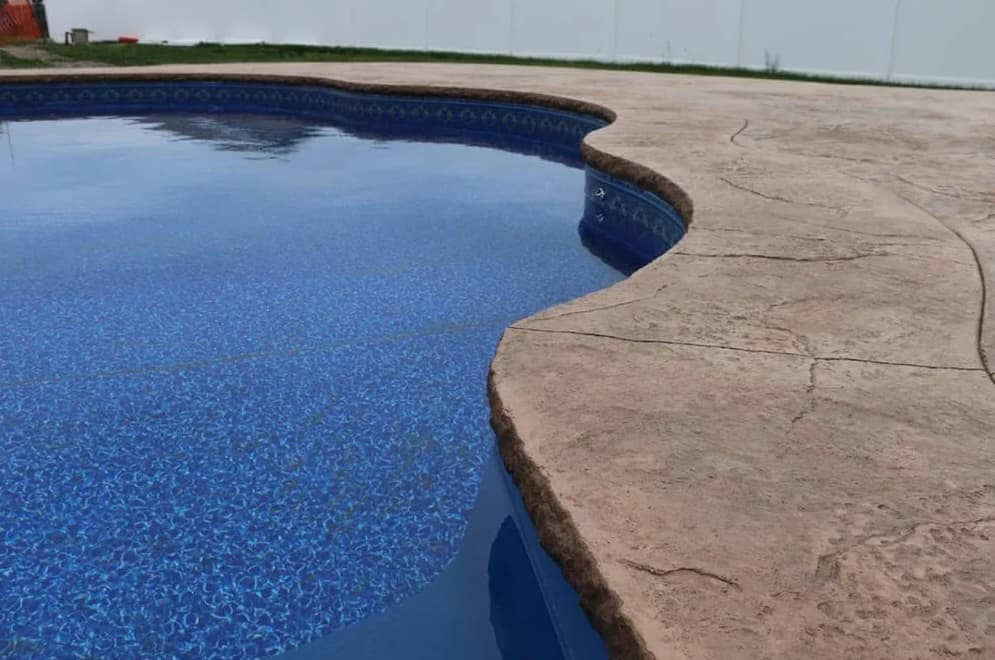 Crew finishing the floor of a new vinyl pool