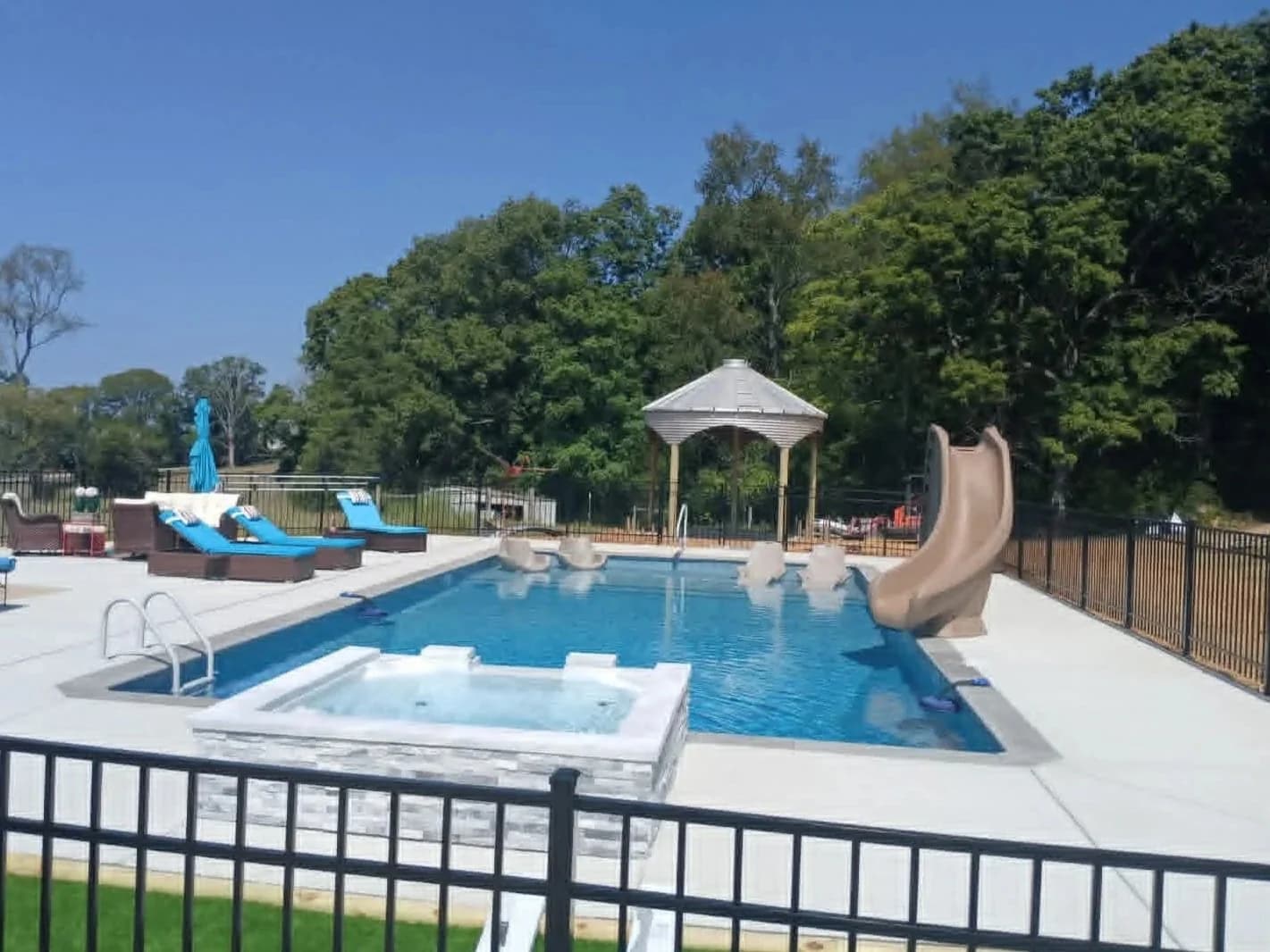 Inground pool with slide, gazebo, and spa