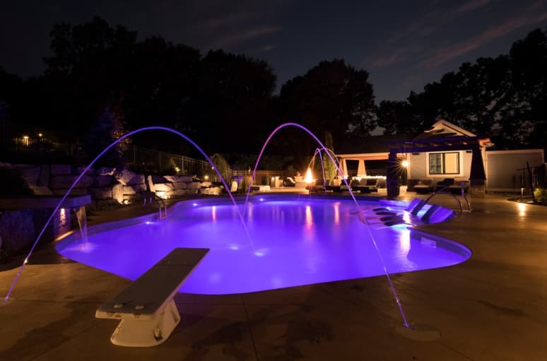 Pool at night with color LED lighting and deck jets