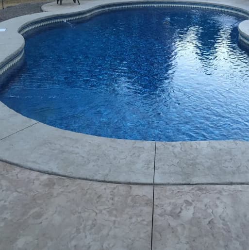 Freeform pool with stamped concrete surround